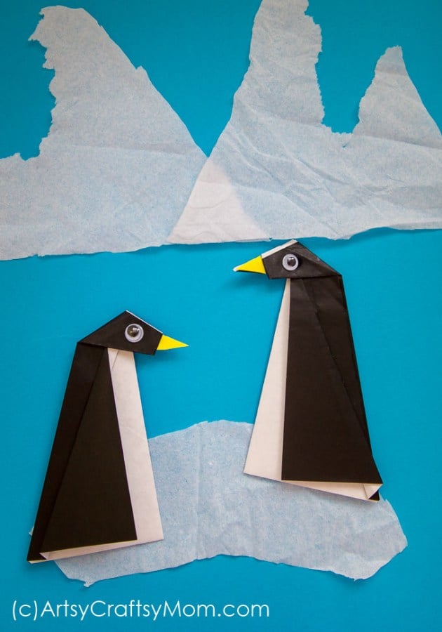 origami penguins on tissue paper ice background