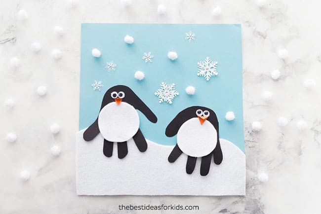 kids handprints turned into penguins on snowy background picture