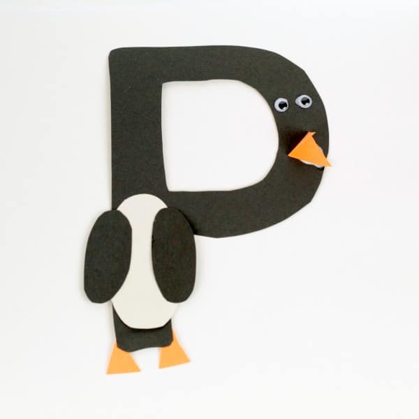 The letter P cut out of paper and styled as a penguin