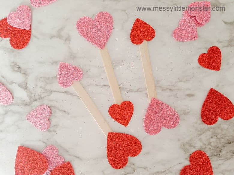 glitter hearts attached to either end of craft sticks to make cupids arrows