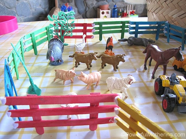 craft sticks made into a fence for toy animals