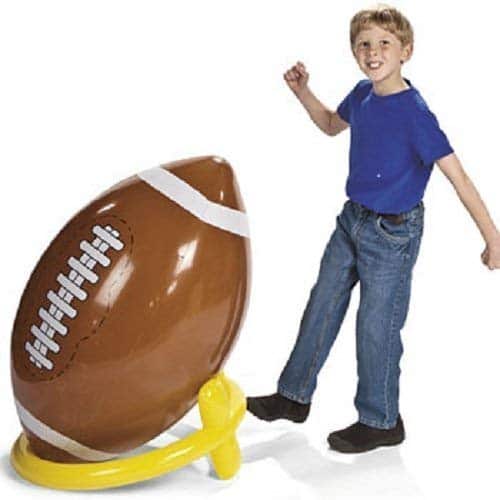 kid kicking giant inflatable football