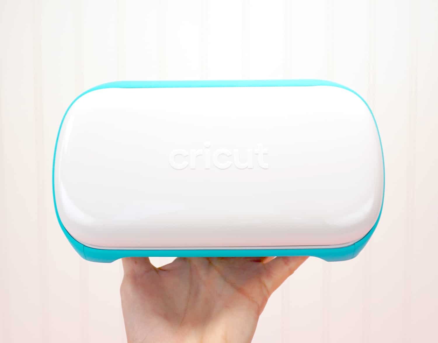 hand holding up a cricut joy