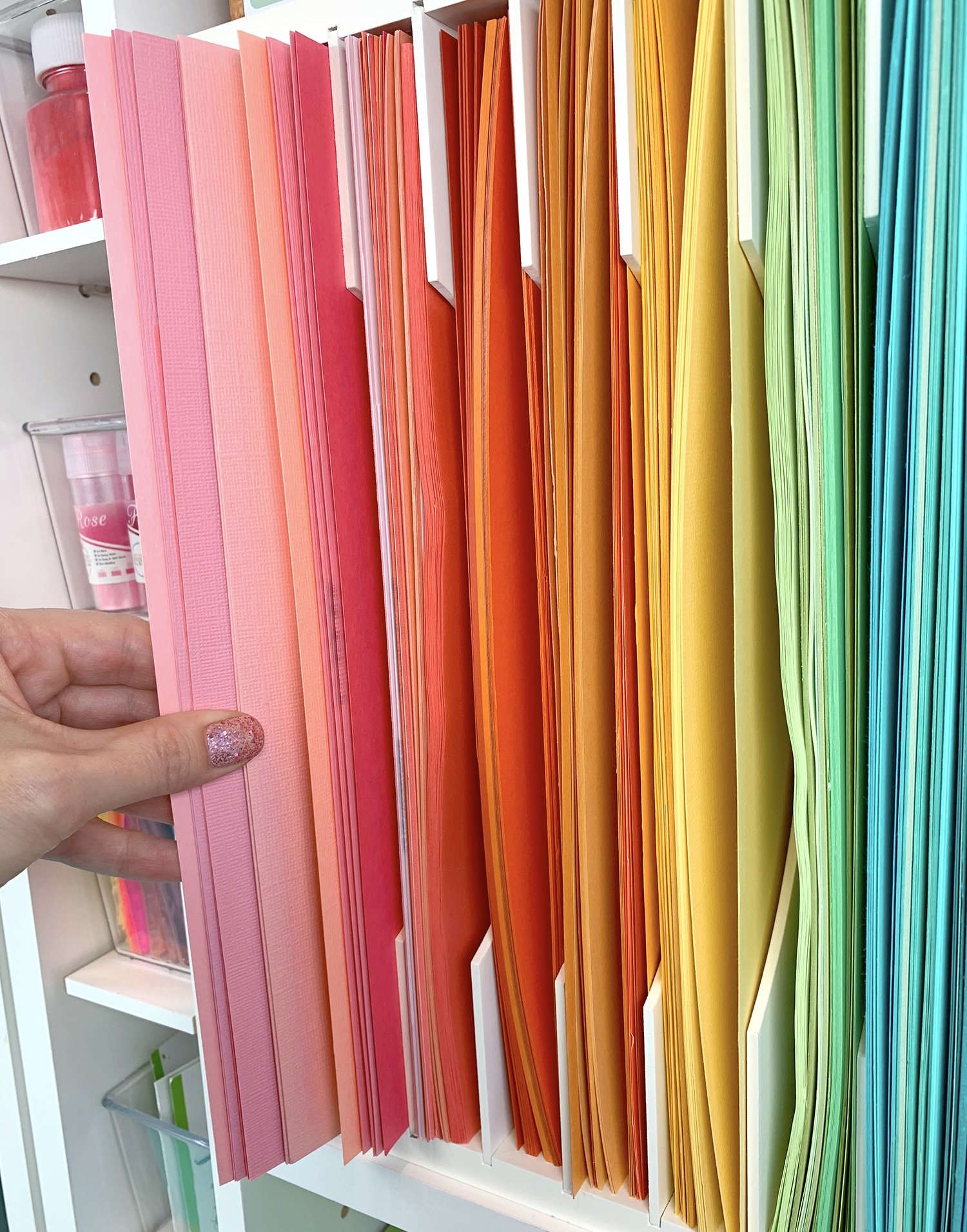 pulling out sheets of paper from rainbow paper organizer