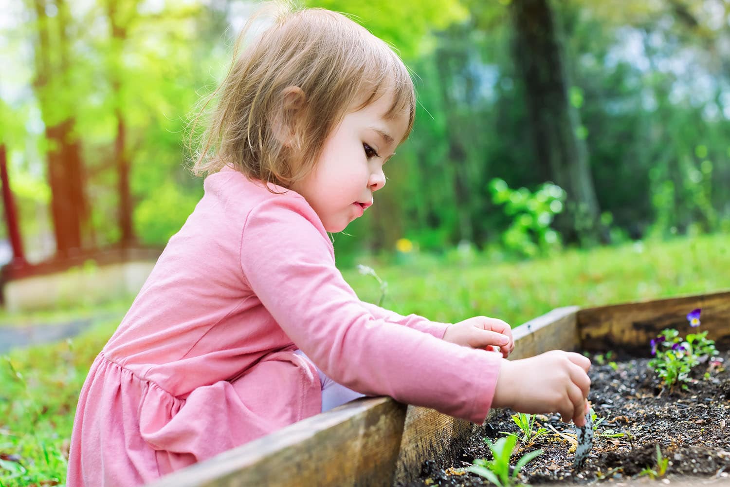 child planting in the garden