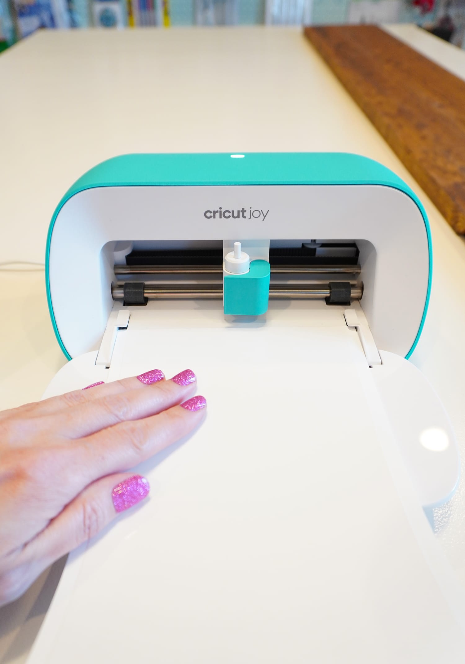 cricut joy with hand feeding smart vinyl into machine