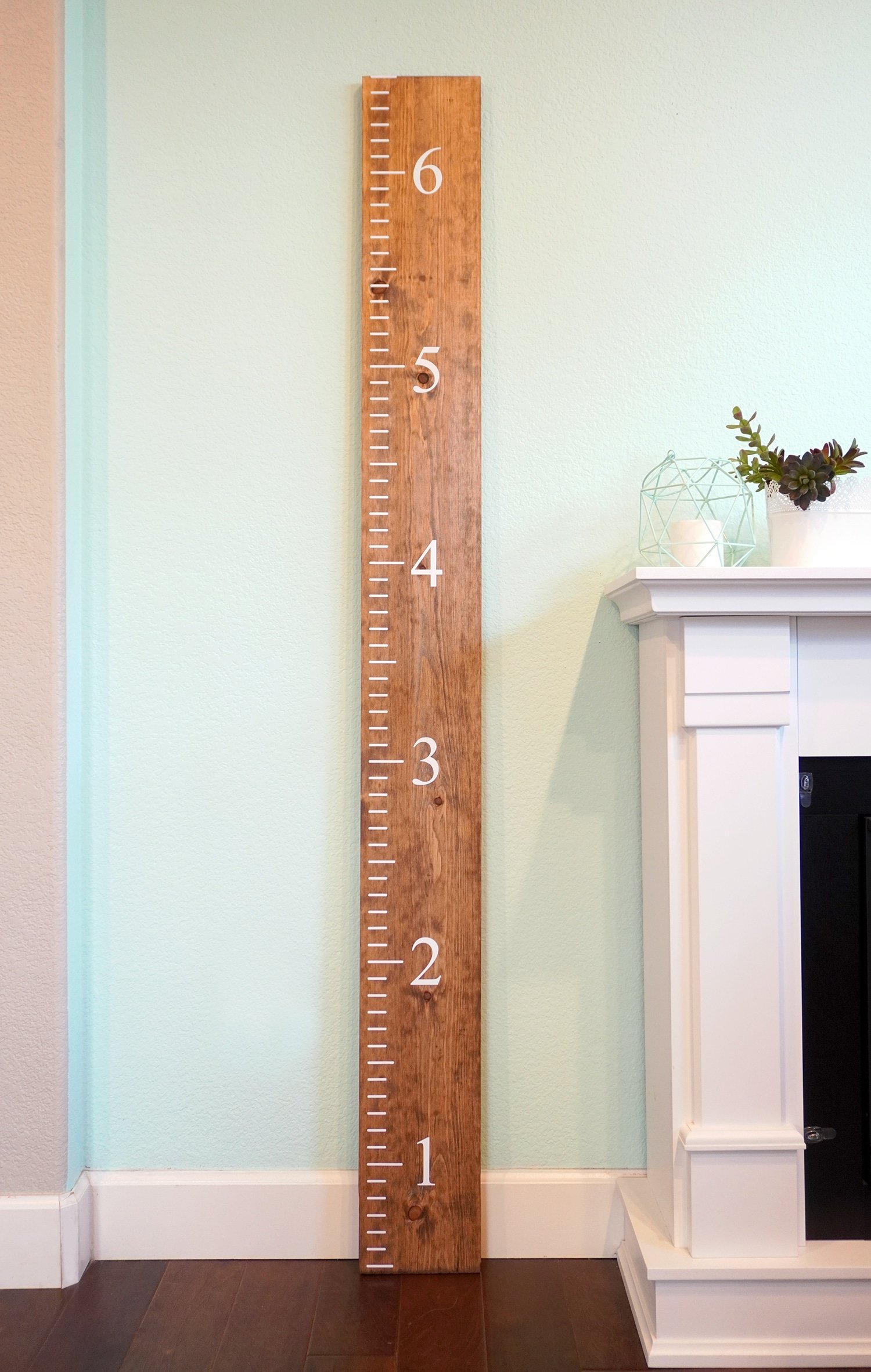 wooden ruler growth chart next to fireplace
