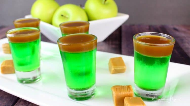 caramel apple jello shots with caramel pieces and apples in bowl