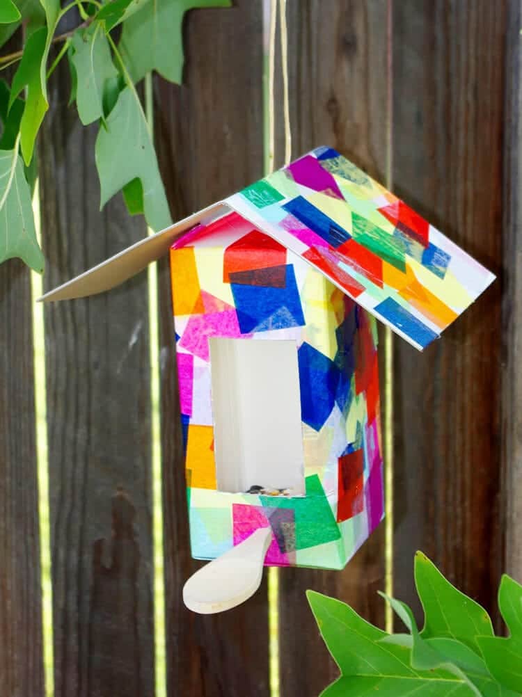 milk carton made into birdhouse hung up in lawn
