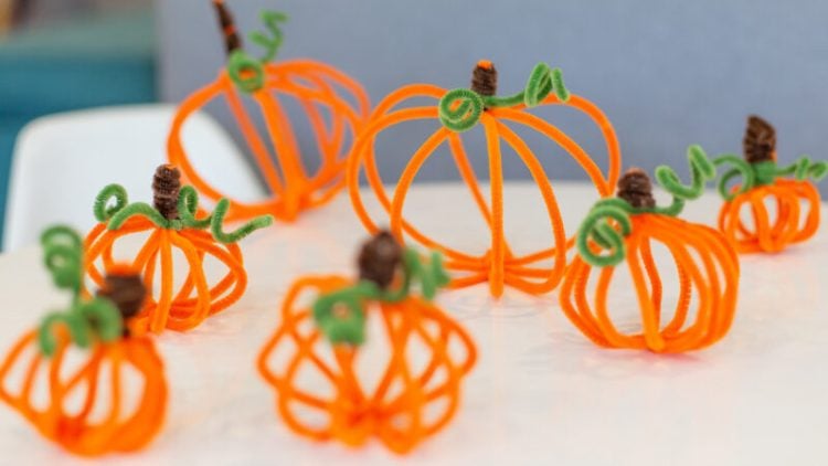 pipe cleaner pumpkins on table