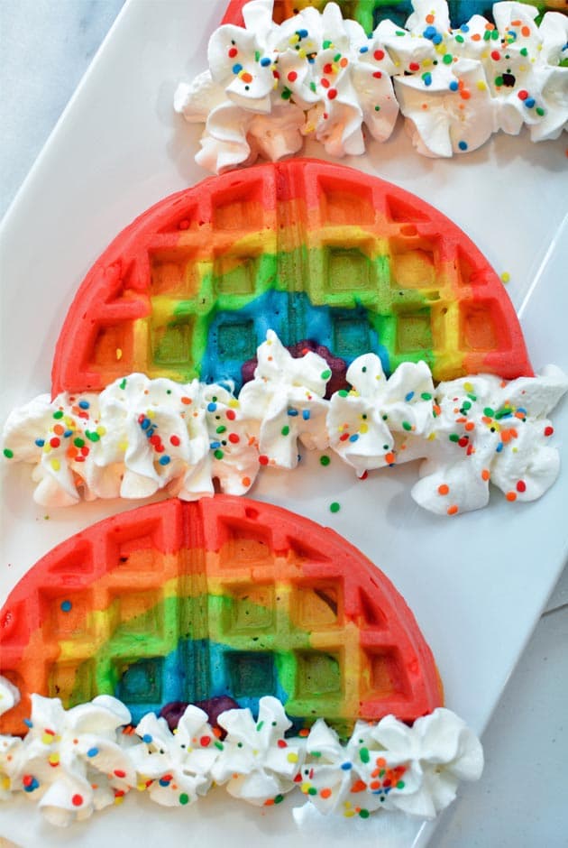 rainbow waffles with whipped cream and sprinkles