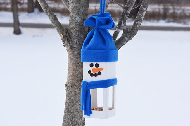 snowman shaped birdhouse in snow