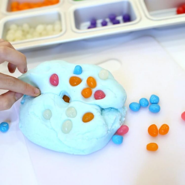 fingers pushing jelly beans into jelly bean playdough 