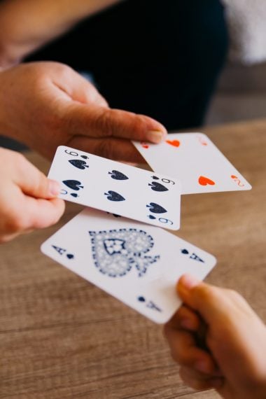 hands exchanging standard playing cards