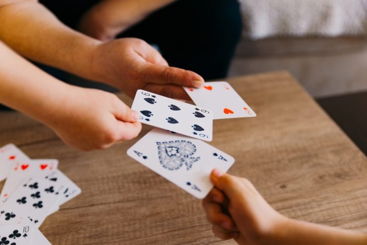 hands exchanging standard playing cards