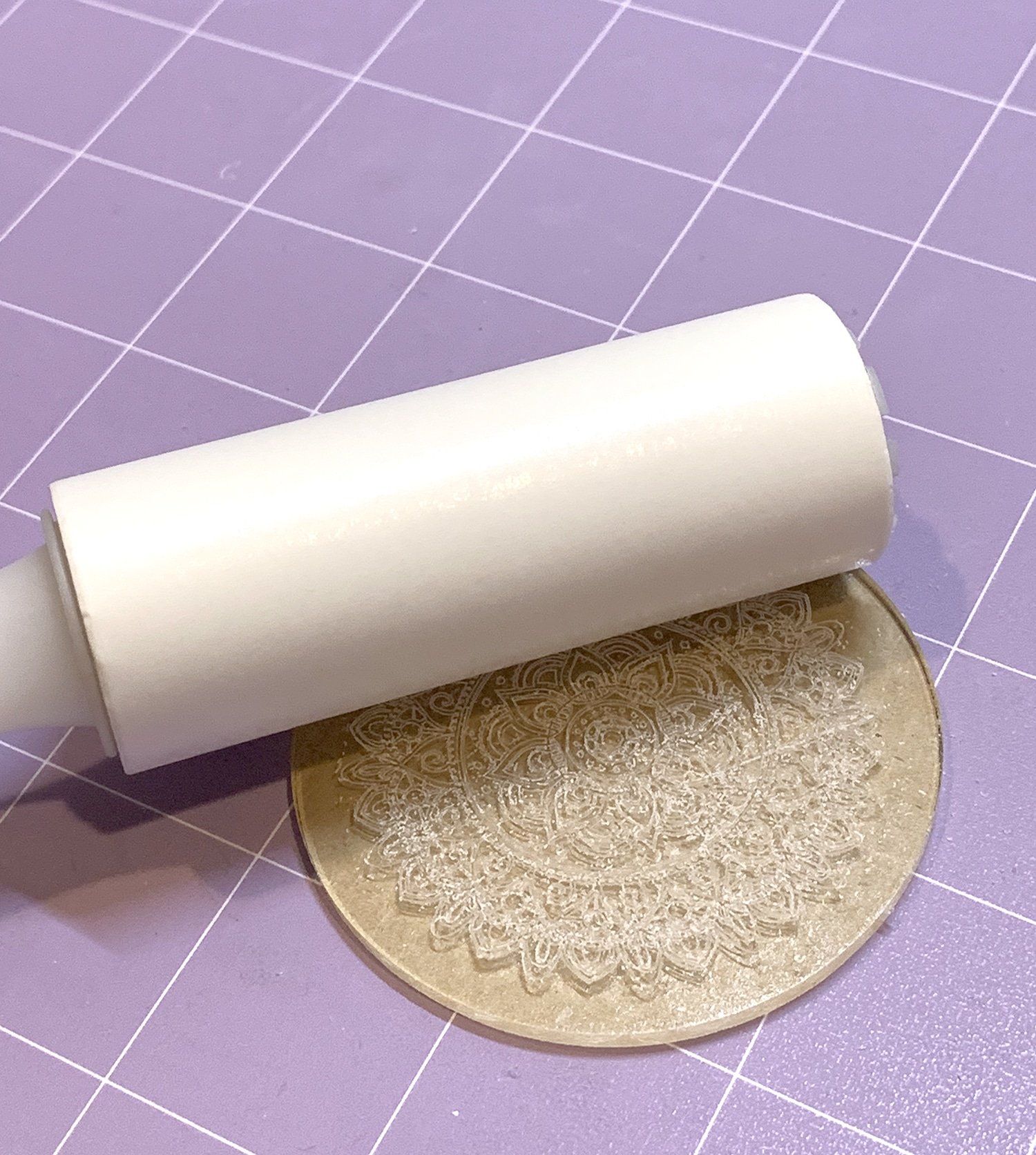 Small lint roller cleaning debris off a Cricut engraved acrylic keychain