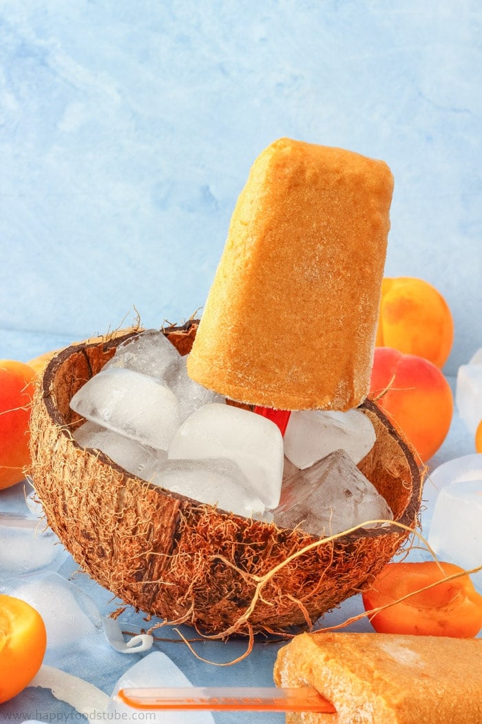 apricot coconut popsicles on ice in coconut