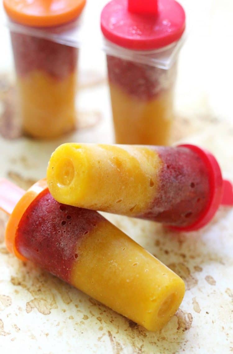 strawberry mango popsicles stacked on a table