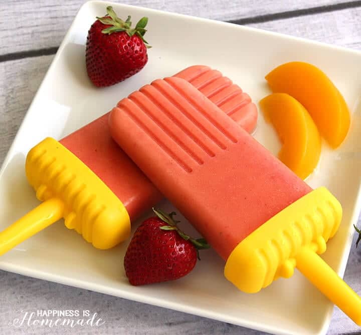 strawberry peach fruit pops on plate with strawberries and peach slices