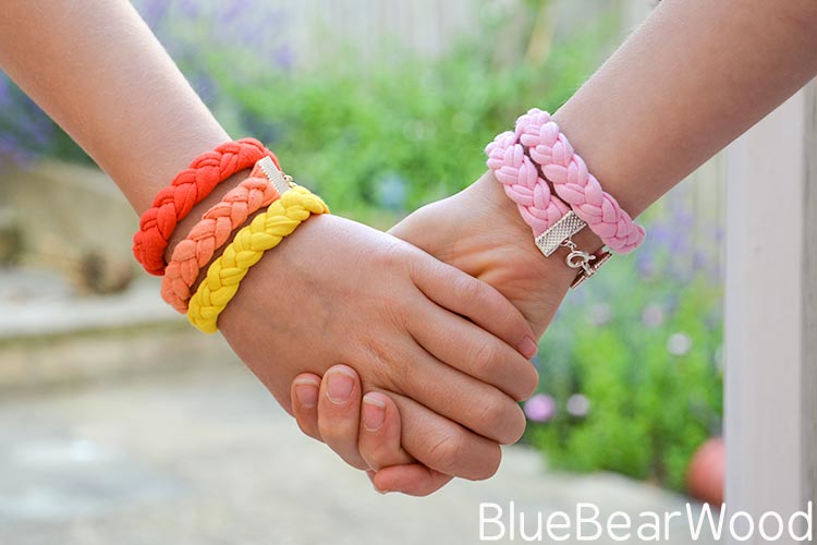 t-shirt yarn bracelets worn on pair of hands being held