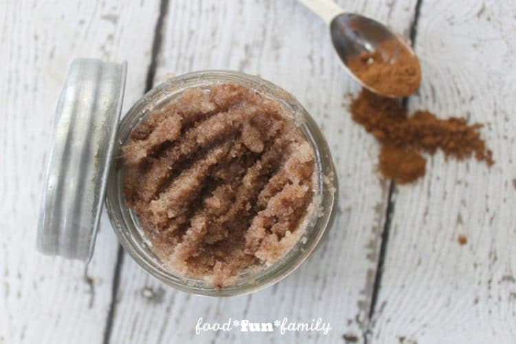 Close up of cinnamon lip scrub in jar with spoonful of cinnamon in background