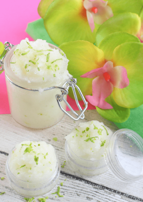 Glass jar of lime mojito sugar scrub on wood and pink background with green orchid flower