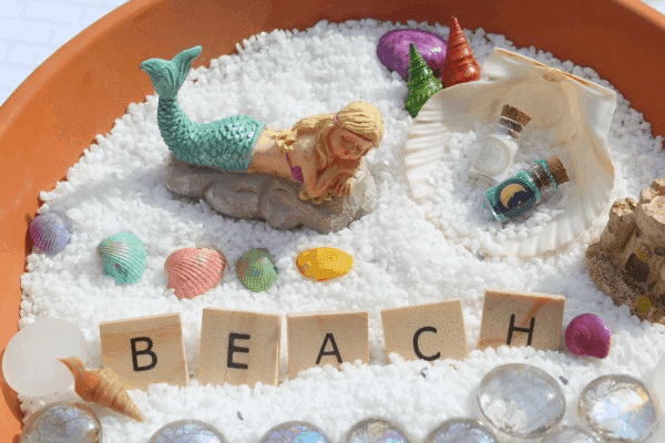 mermaid fairy garden with the word \"beach\" 