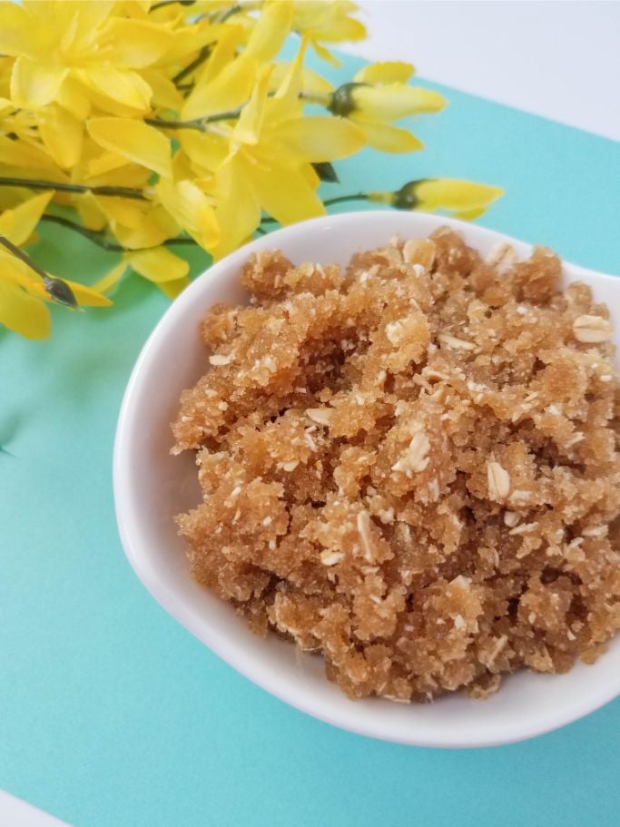 Close up of oatmeal and brown sugar body scrub on a blue background