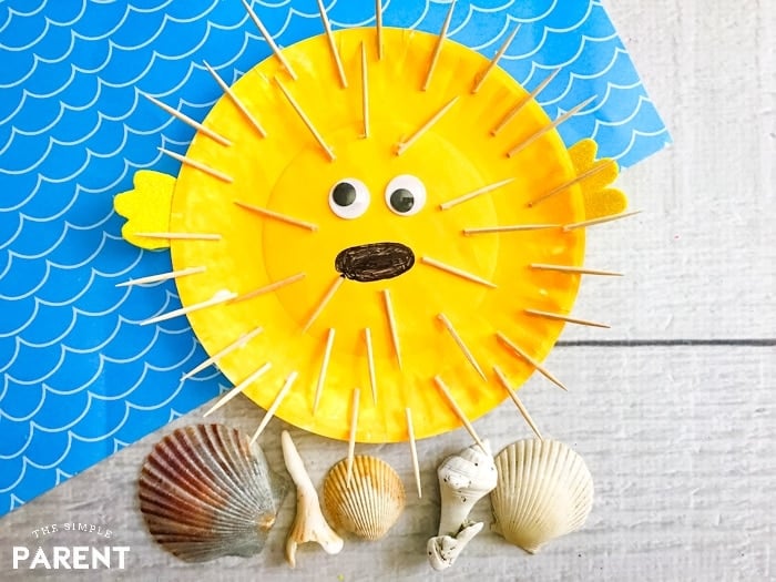 yellow puffer fish made from paper plate and toothpicks with shells