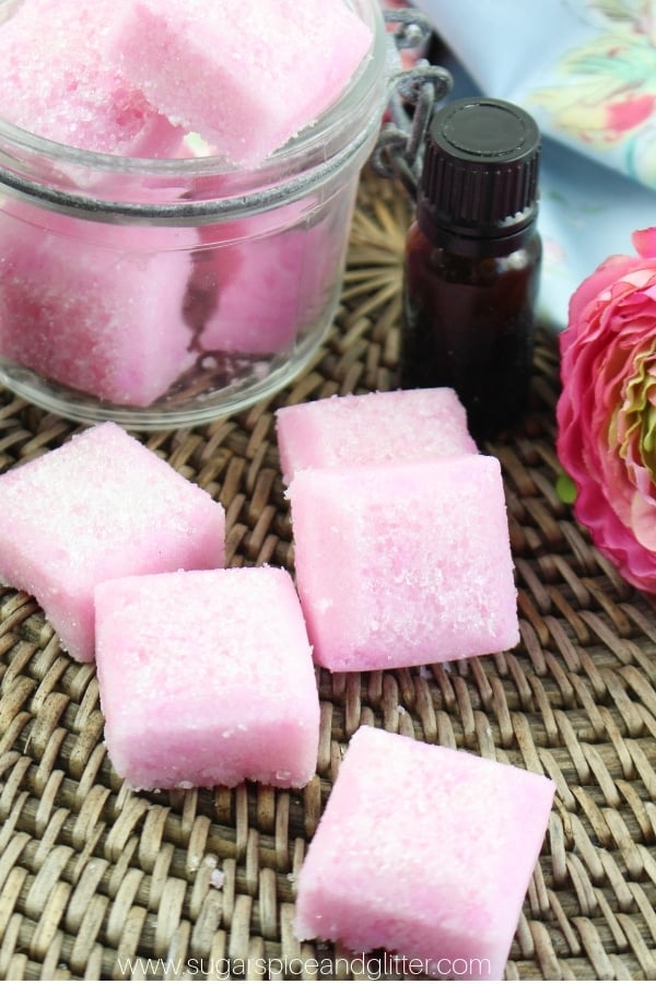 pink rose and jasmine sugar scrub cubes on a textured rattan background