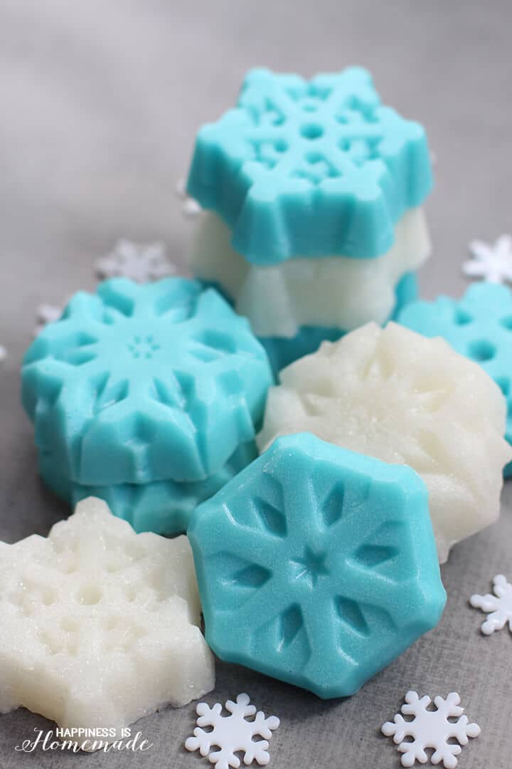 Blue and white snowflake shaped sugar scrub cubes on a grey background