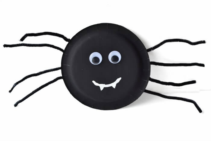 spider face smiling made from paper plate and pipe cleaner legs