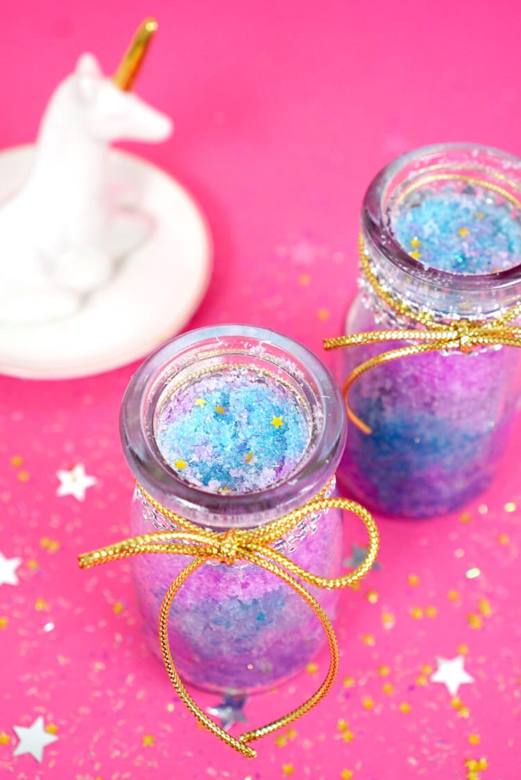 Colorful DIY unicorn sugar scrub on pink background with unicorn and stars