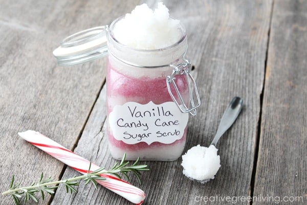 jar of pink and white body scrub with \"Vanilla Candy Cane Sugar Scrub\" label and candy cane on wood background