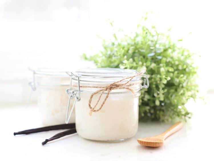 Jar of vanilla sugar scrub with spoon and vanilla bean