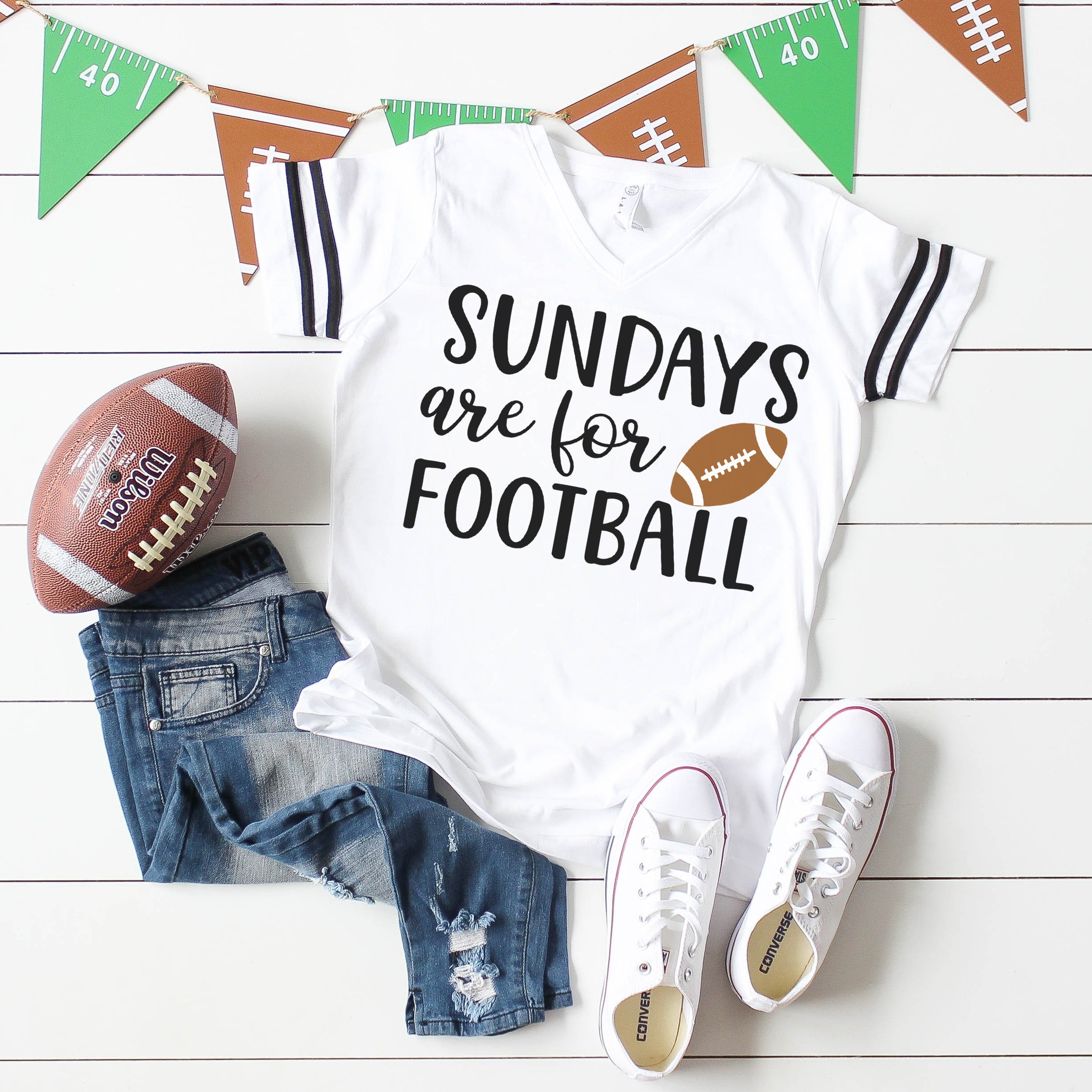 "Sundays are for Football" Shirt on white wood background with football, jeans, white shoes, and football banner