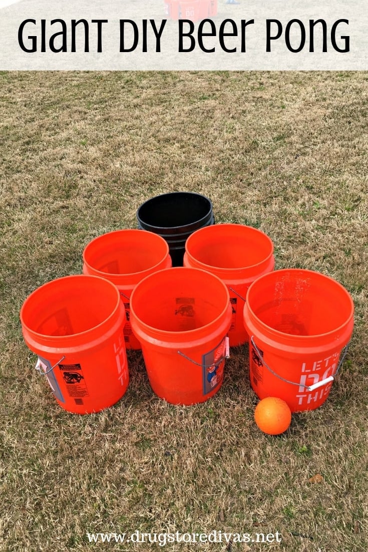 Large gallon buckets set up on lawn in formation with a ball