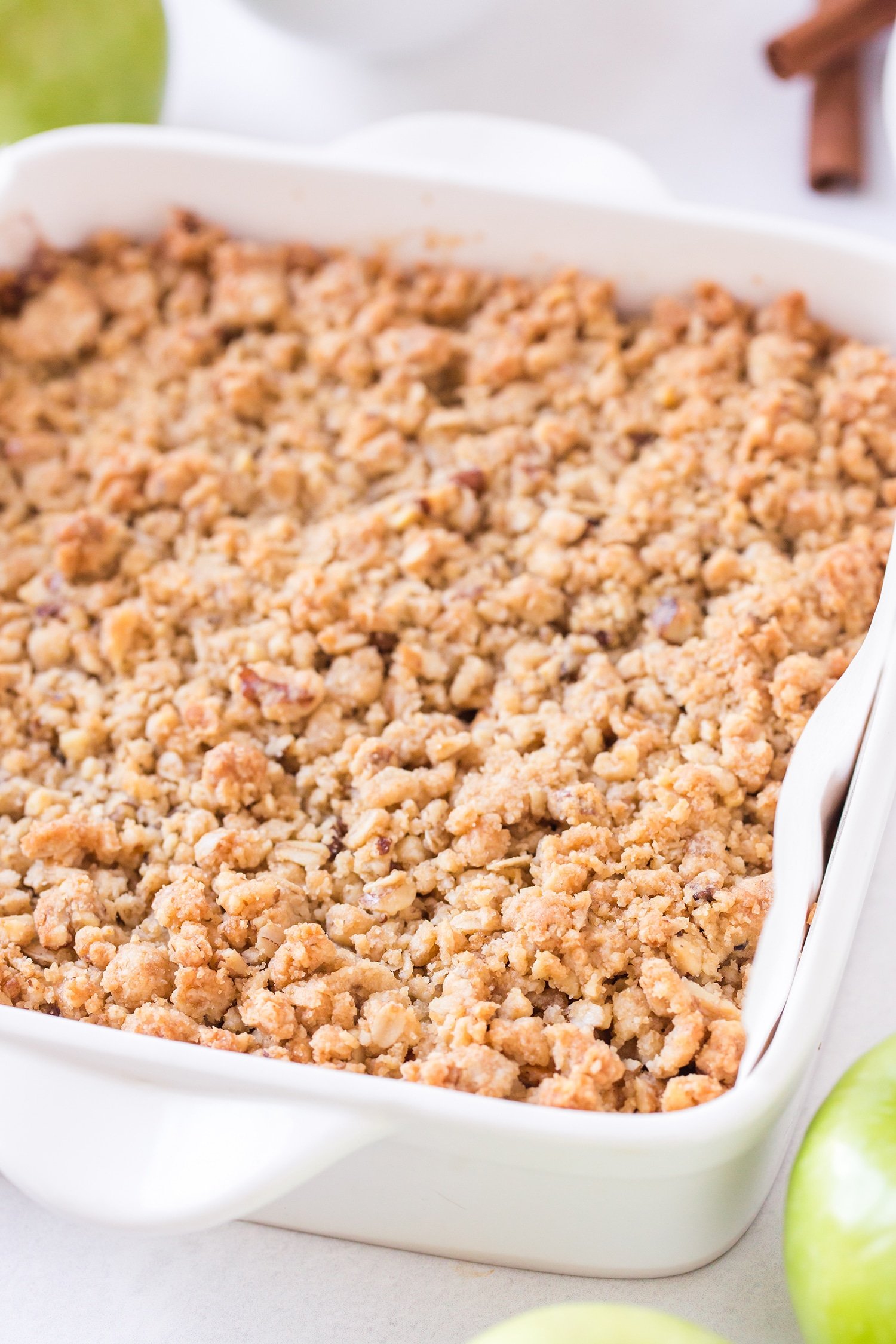 Close up of streusel topping on apple pie bars in white baking dish