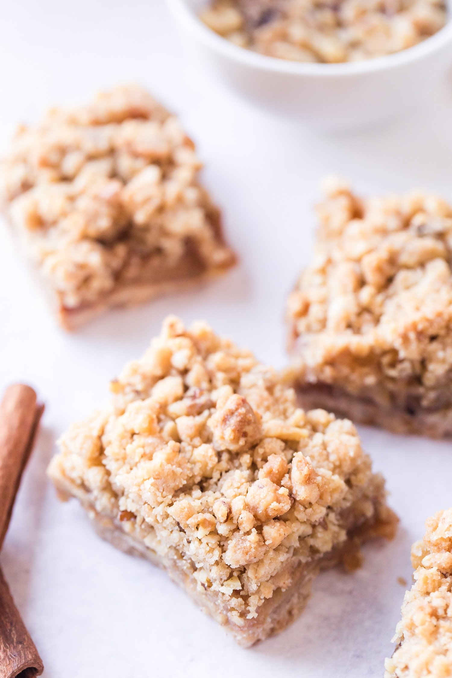 Apple pie bar on white background next to cinnamon sticks