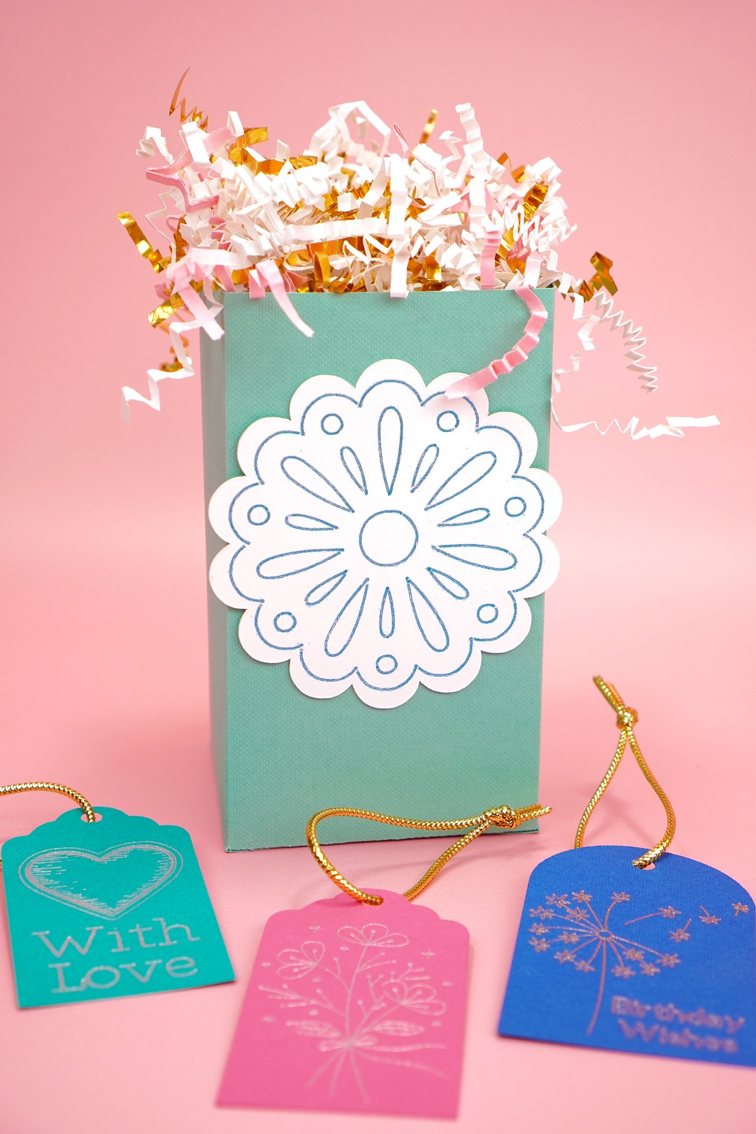 Mint green gift box with foil flower design and foil gift tags on pink background