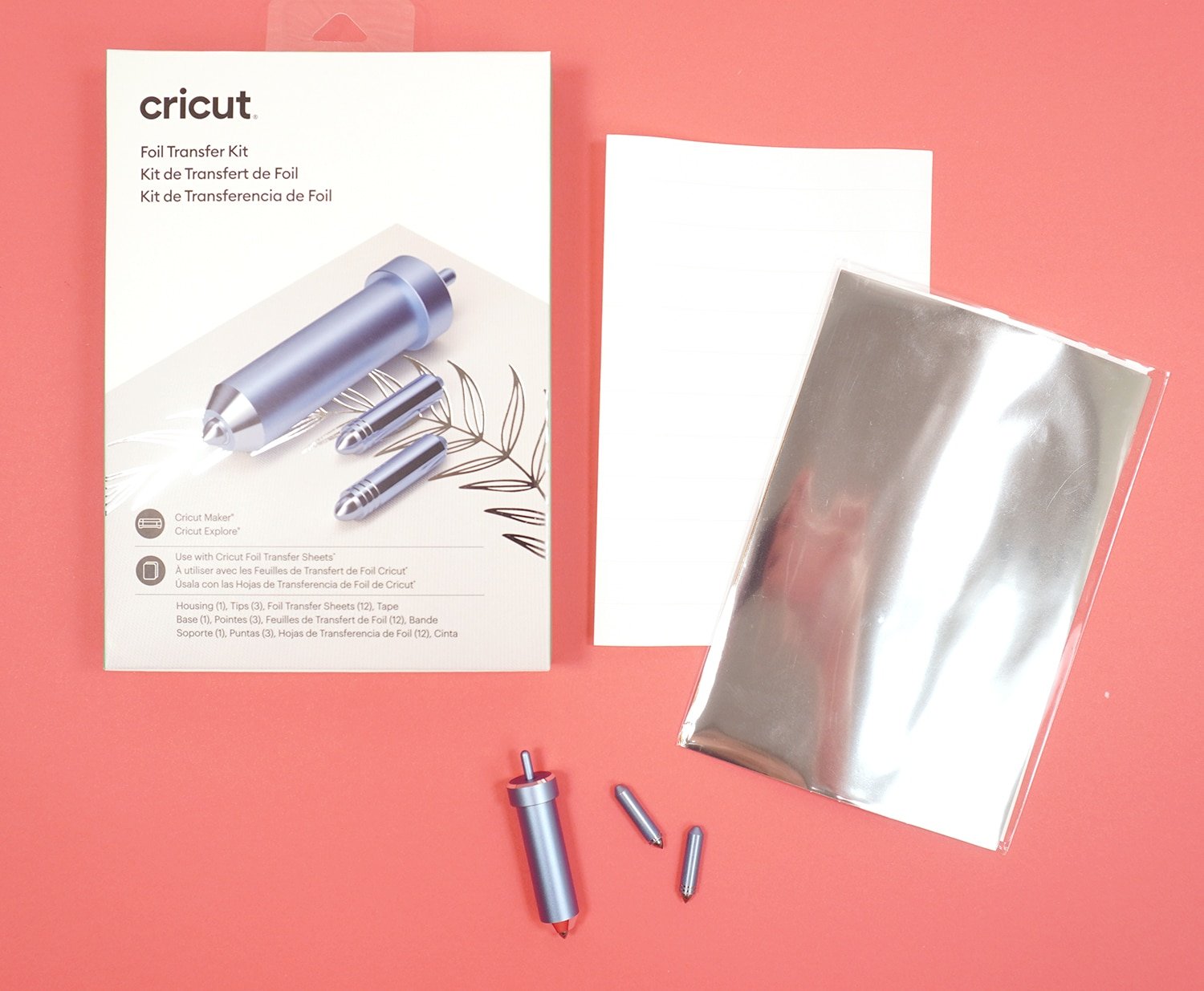 Cricut Foil Transfer Kit packaging, tool, tips, and silver foil on coral background