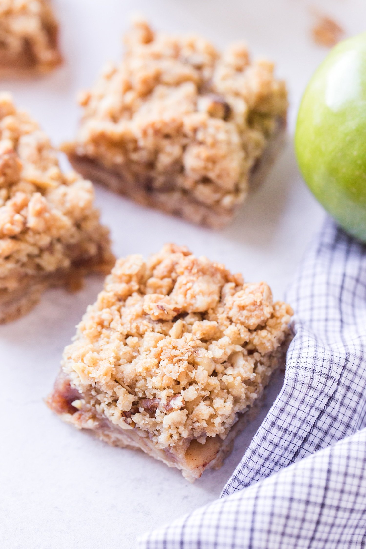 Cut apple pie bars with green apple in background