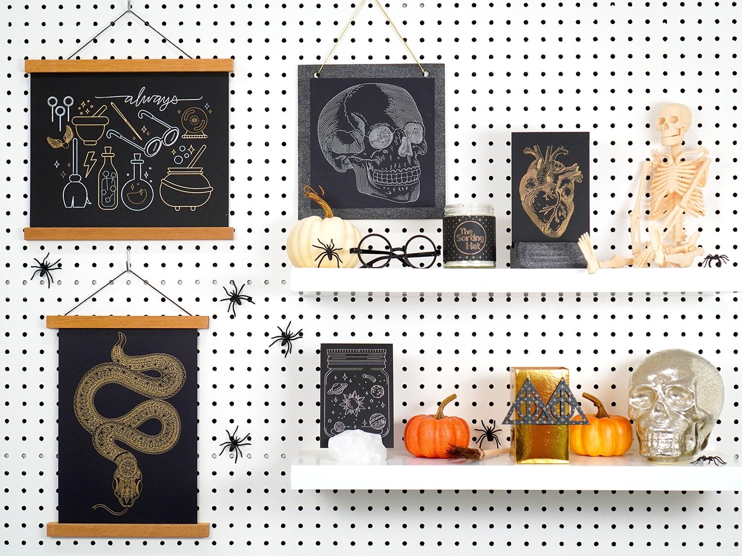 Foil Halloween art prints and Halloween Decorations on white shelves and pegboard