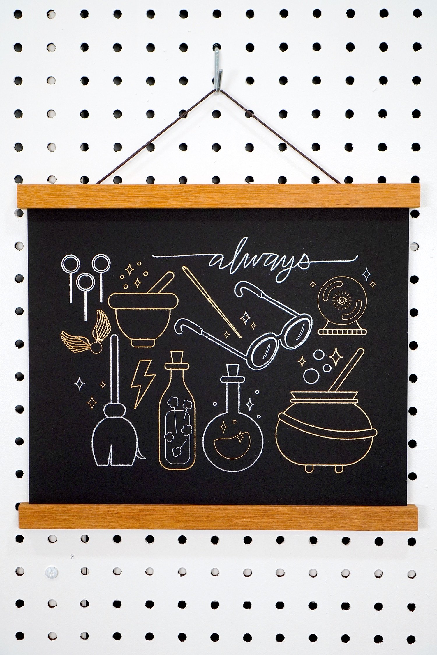 Gold and Silver Foil Harry Potter Artwork hanging on pegboard