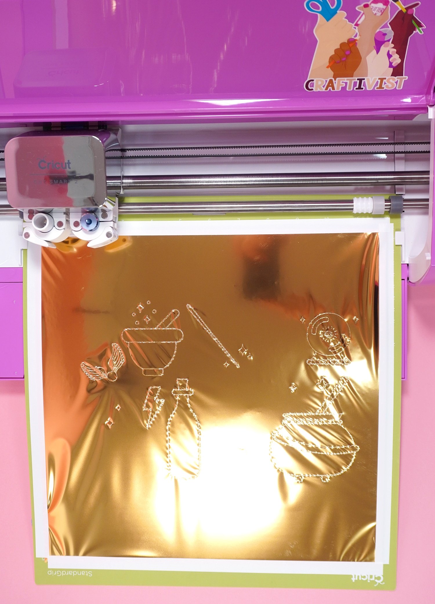 Gold foil with Harry Potter inspired designs on mat in pink Cricut Explore Air 2 machine