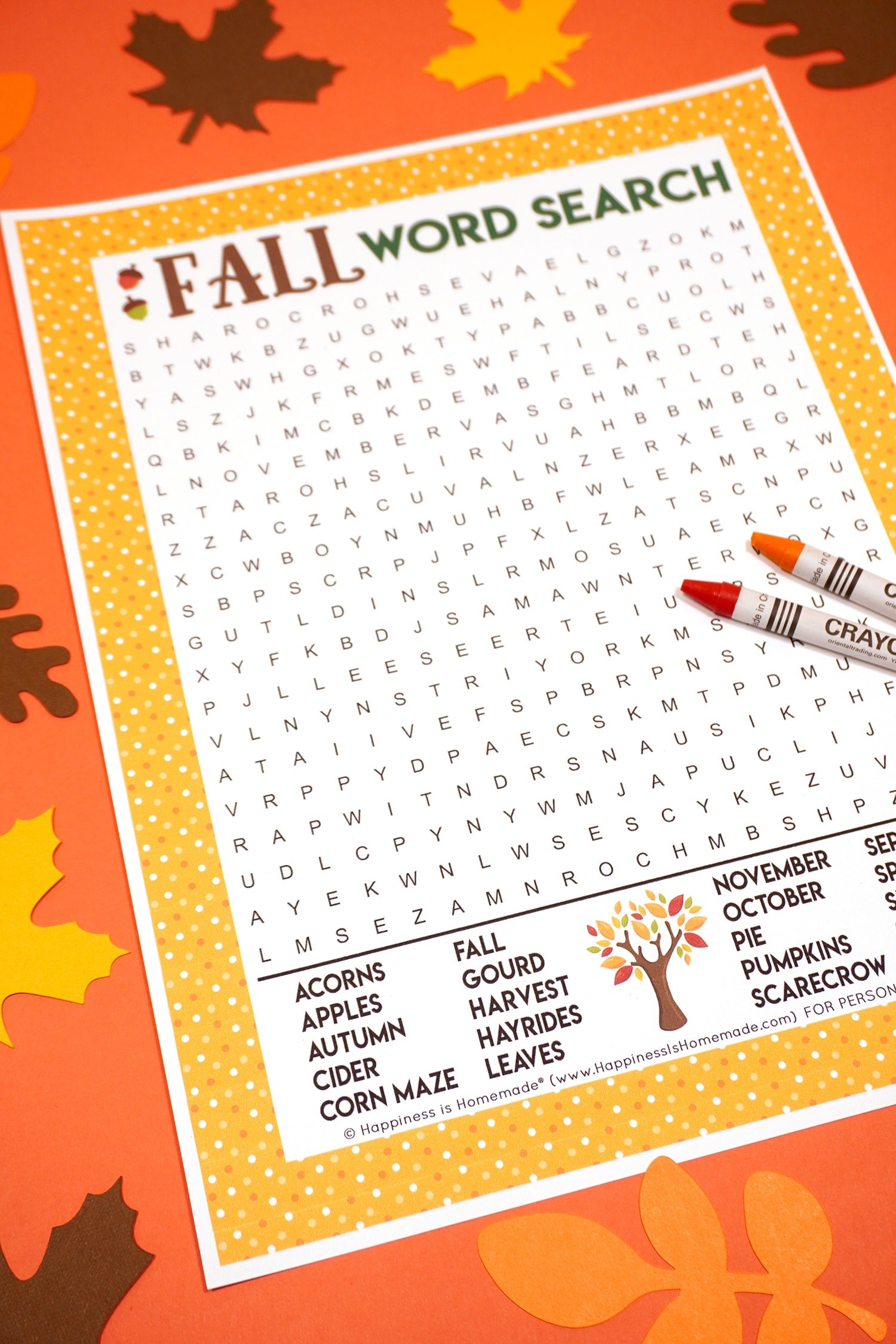 Fall Word Search Printable on dark orange background with orange and red crayons surrounded by paper leaves