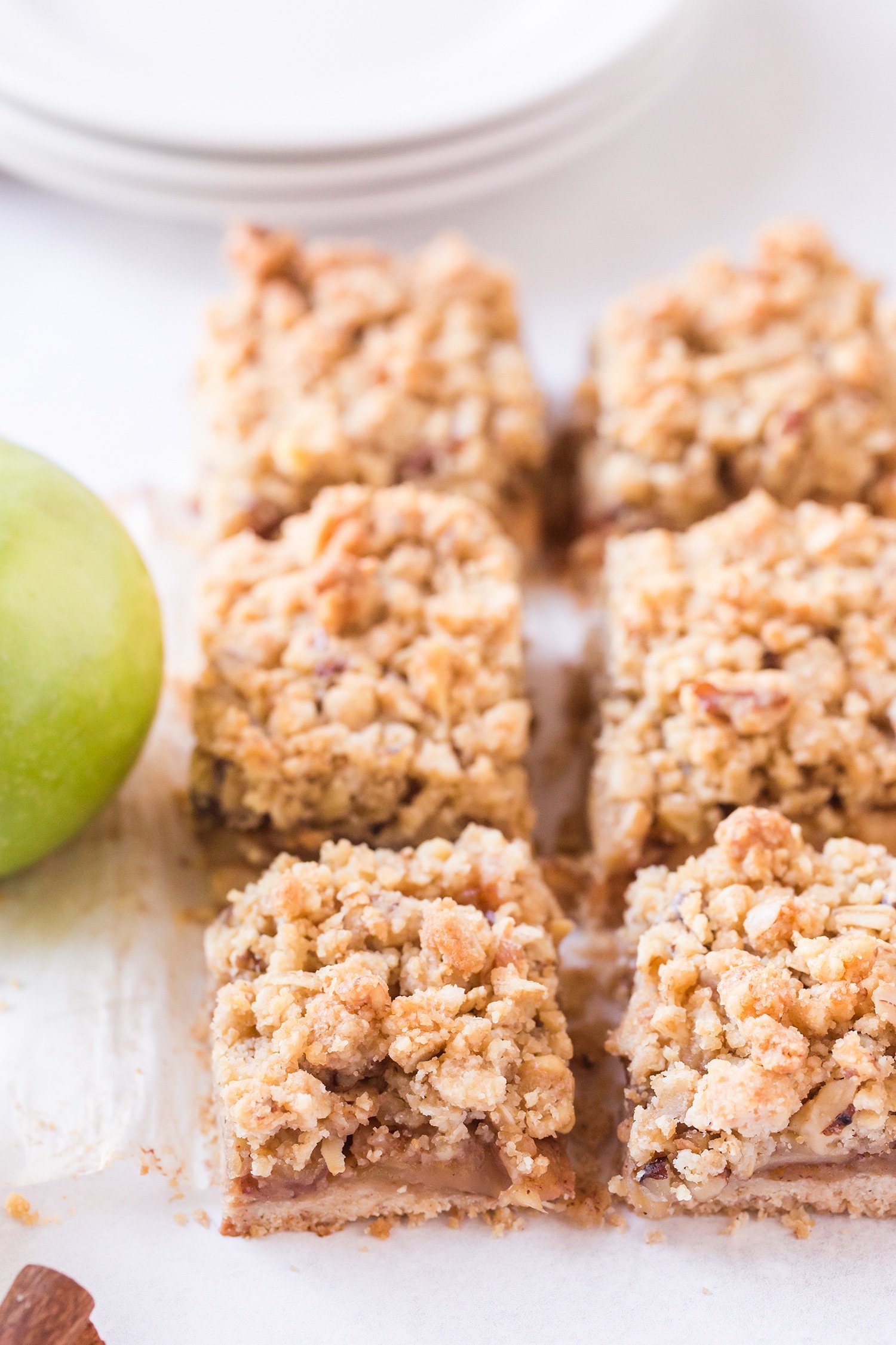Sliced apple pie bars with green apple in background