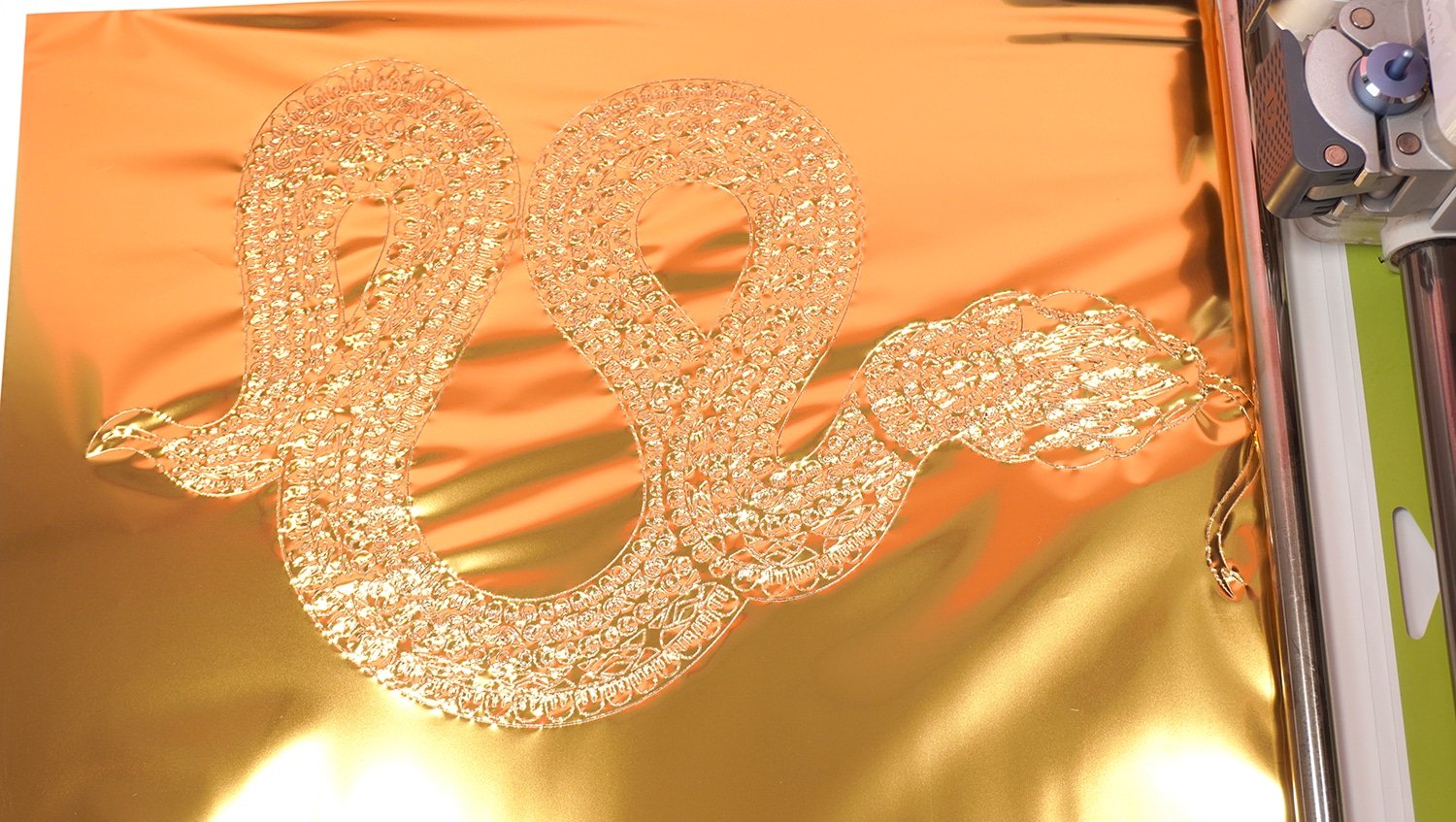 Close up of gold foil transfer sheet with snake design