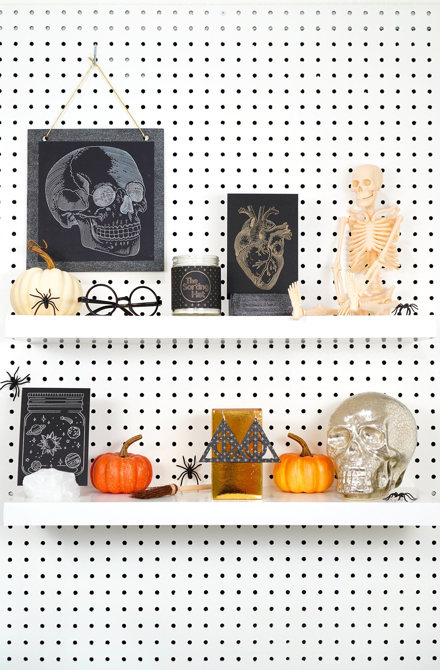 Shelves decorated with Halloween props and Halloween foil art prints