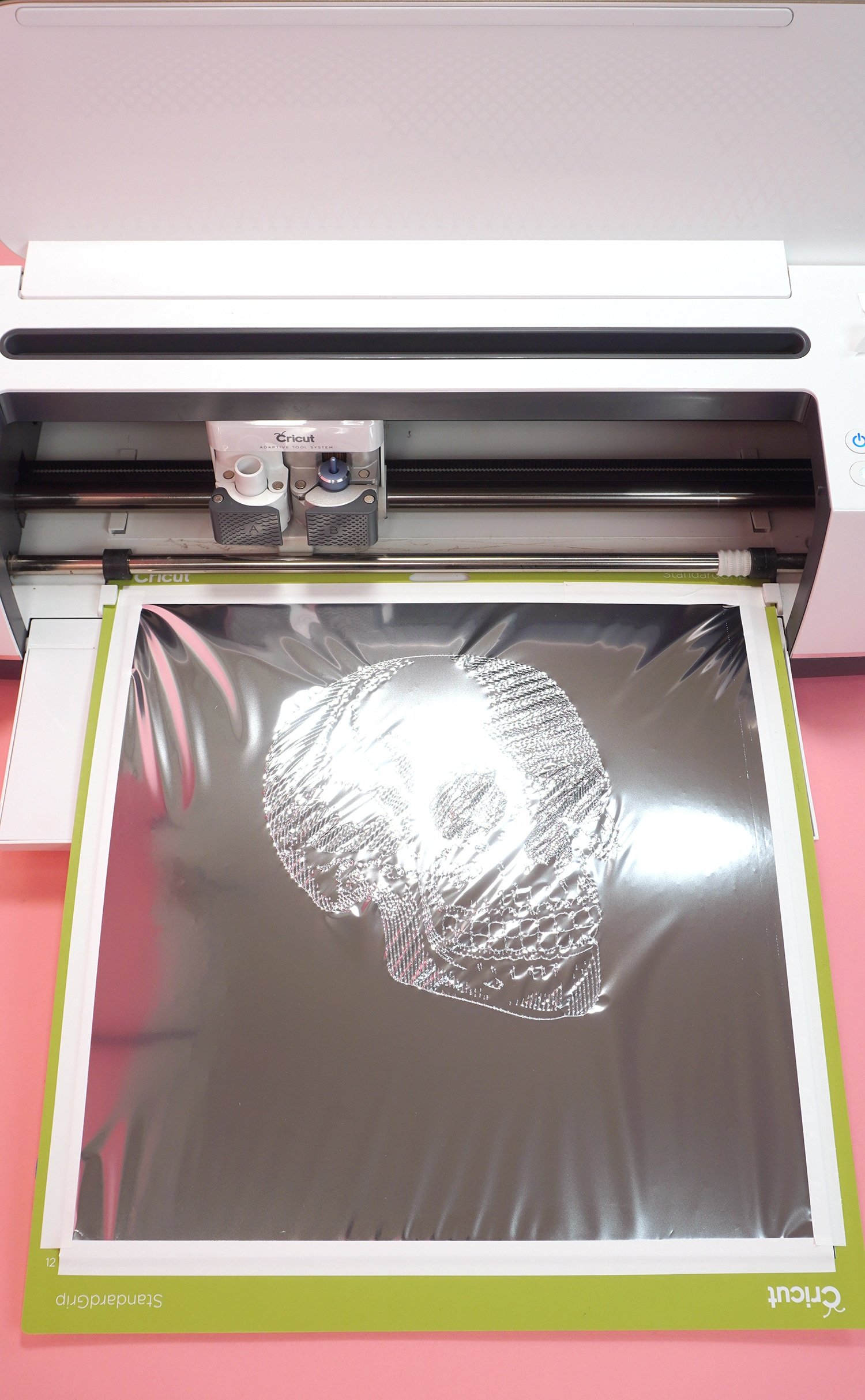 Silver foil with skull design on Cricut mat in Cricut Maker machine